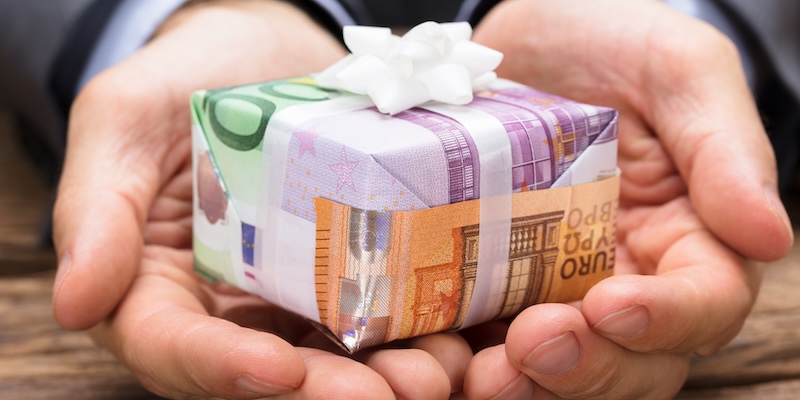 Geldgeschenk in Händen - Symbolbild für Bonus bei Scalable Capital Depotübertrag AB
