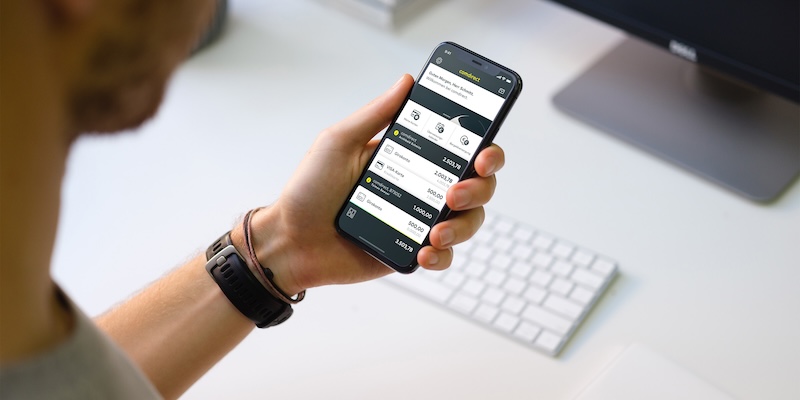 Mann hält Handy mit Comdirect App in der Hand - Symbolbild für Comdirect Zinsen Aktion AB